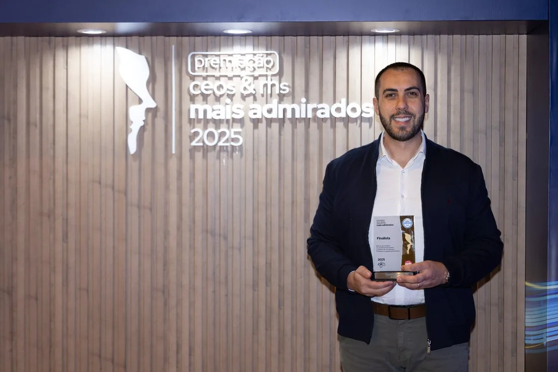 Gustavo Fermino segurando o troféu do prêmio CEOs e RHs Mais Admirados